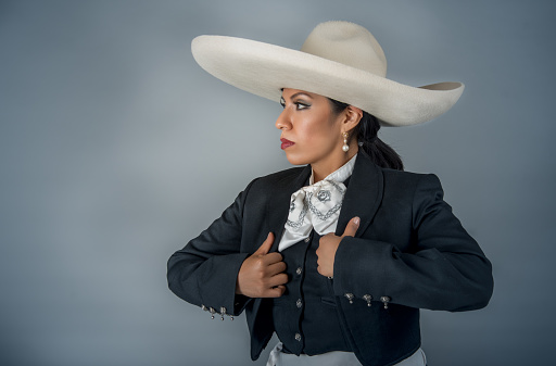 Latin Mexican Woman Dressed in Charro Costume Hands Jacket with Silver Buttoning
