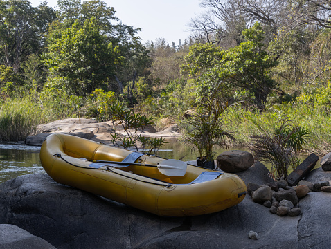 Yellow boat is laying on the rock near river. Africa.