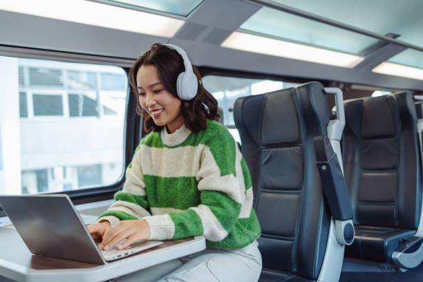 young asian woman working on a laptop in train - high speed train audio zdjęcia i obrazy z banku zdjęć