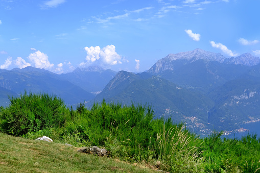 beautiful mountain landscape, green hills above Lake Como in Italy, mountains against backdrop of blue sky, concept of tourist season, outdoor adventure