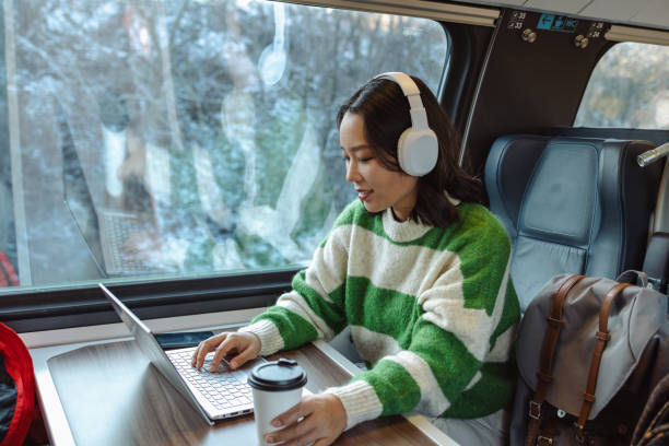 młoda azjatka pracująca na laptopie w pociągu - high speed train audio zdjęcia i obrazy z banku zdjęć