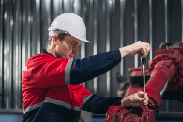 Robotic technician conduct specialized maintenance on an industrial robotic arm in a manufacturing plant.