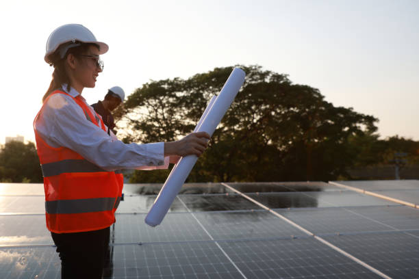 istock Female engineer, with solar panel blueprint or outdoor on the rooftop for power, sustainability plan, or energy development.  photovoltaic technician  or reading on the roof 1973643844