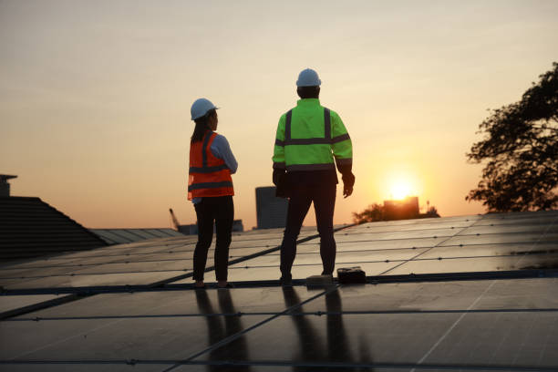 istock Silhouette Site Solar service engineer team working on a solar rooftop against the sunset 1973644381