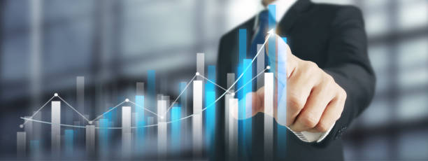 istock Businessman with chart financial symbols coming from hand 1973655294