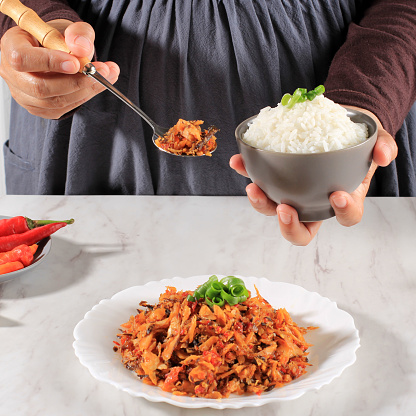 A Woman Hold A Bowl of White Rice with Spicy Shredded Tuna Fish, Concept Daily Asian (Korean Japan Thailand) Menu. Selected Focus