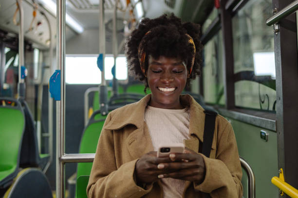 istock Young woman using smart phone while while driving by public transport 1973691435