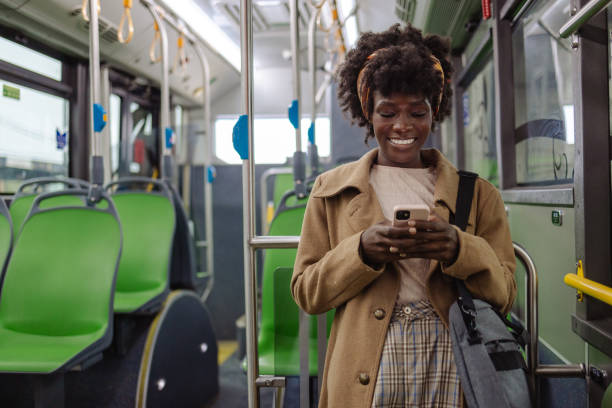 istock Young woman using smart phone while while driving by public transport 1973691436