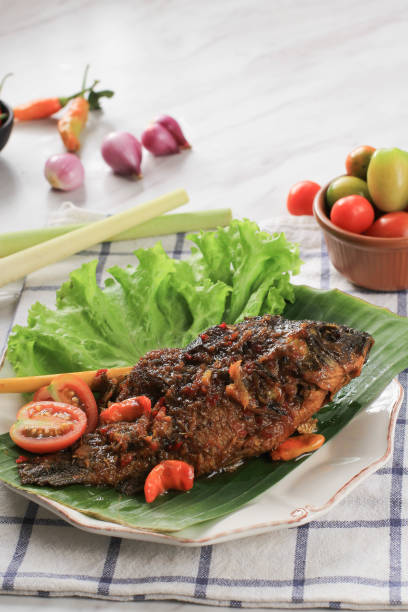 istock Pesmol Fish Using Goldfish. Add Fried Fish to the Pan. Pesmol Typically Fish Recipe from West Java, Indonesia, with Sweet, Sour, and Spicy Taste 1973692457