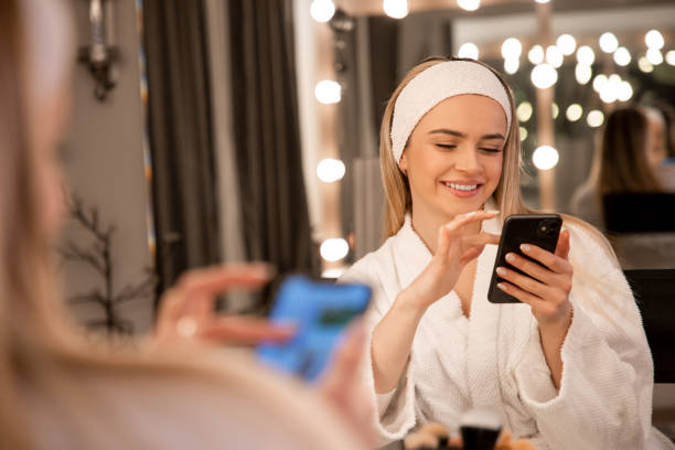istock Glamorous Moments: Young Makeup Artist Using Phone with a Smile in Celestial Ambiance 1973708373