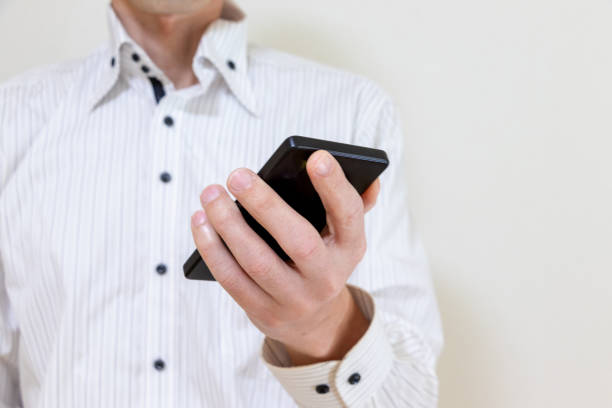 istock A man in a white shirt holding a smartphone in one hand 1973759522