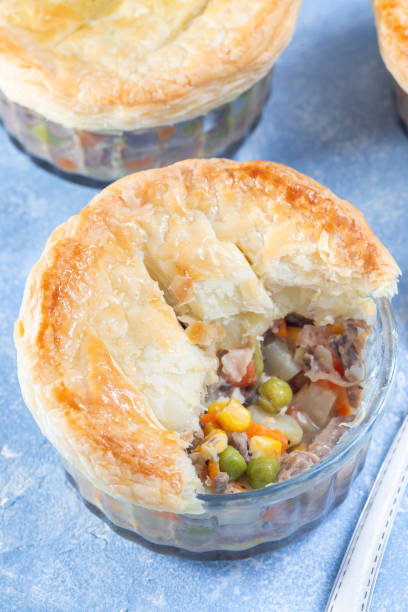 istock Individual beef pot pie or deep dish pie in ramekin, crust broken open to show the inside, vertical 1973765741