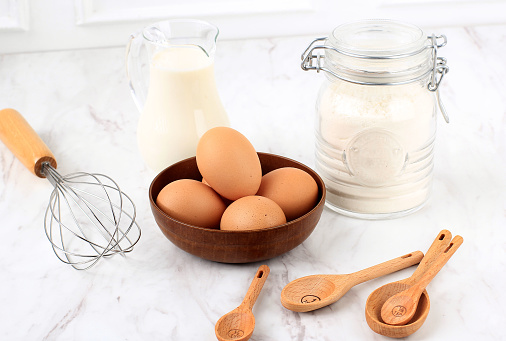 Eggs, Flour, Milk, Sugar, Measuring Spoon,  and Wire Whisk. Preparation for Baking