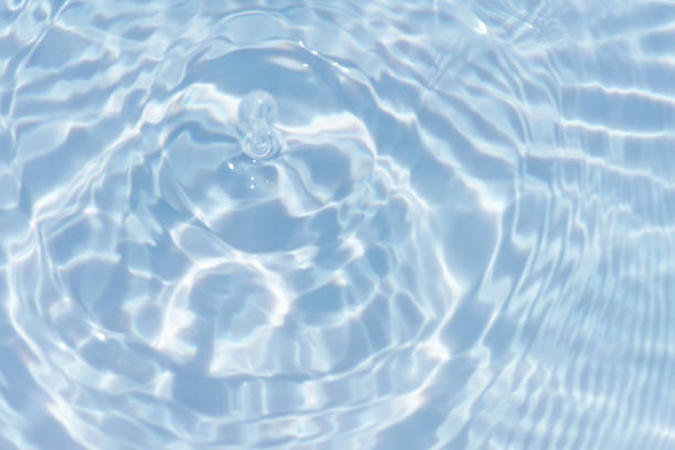 istock Water surface. Bluewater waves on the surface ripples blurred. Defocus blurred transparent blue colored clear calm water surface texture with splash and bubbles. Water waves with shining pattern. 1973868592