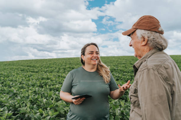 Female agronomist and farmer talking on plantation