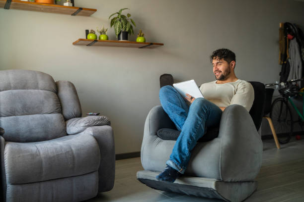 istock Man looking at social media on his cell phone while relaxing at home 1973941046