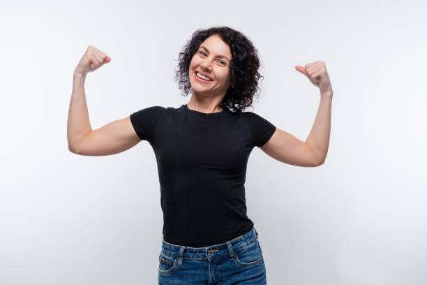 istock Dreamy brunette with curly hair shows muscles 1973945717