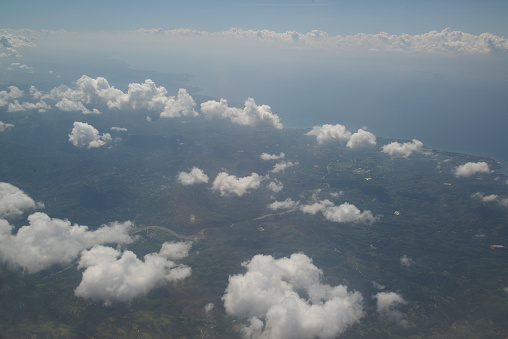 Nature background of sky view with clounds from above from airplane and see the land below.