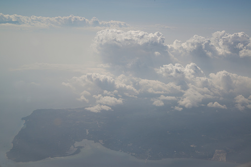 Nature background of sky view with clounds from above from airplane and see the land below.