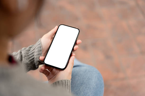 istock A close-up image of a woman using her smartphone while sitting outdoors. a smartphone mockup. 1973995866