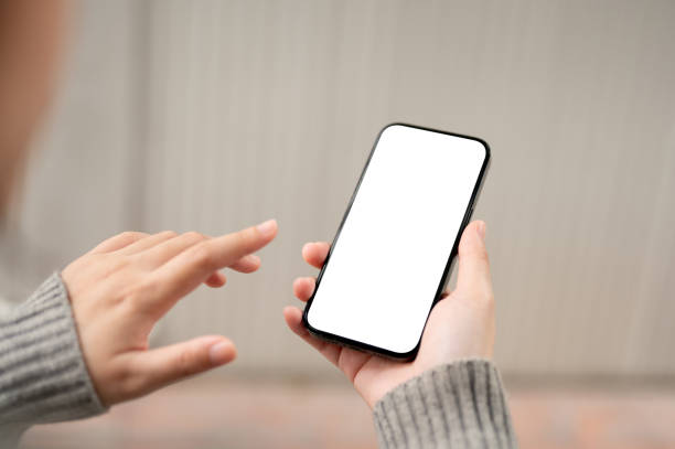 istock A close-up image of a white-screen smartphone mockup in a woman's hand with a blurred background. 1973998977