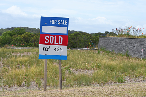 Land for sale sign with a sold sticker