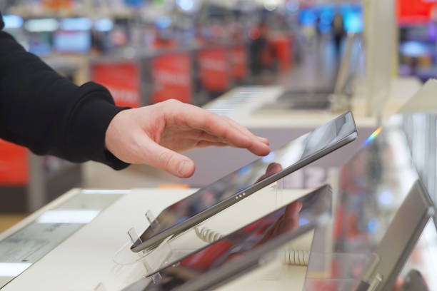 istock A white man uses a digital tablet in an electronics store. 1974018800
