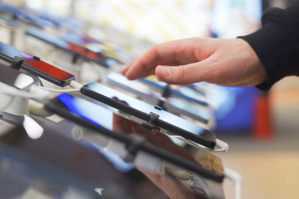 istock Hand of male buyer testing smartphone in electronics store 1974018814