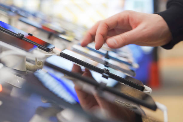 istock Hand of male buyer testing smartphone in electronics store 1974018815