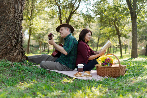 istock Elderly man relaxes with his guitar while his wife reads 1974021603
