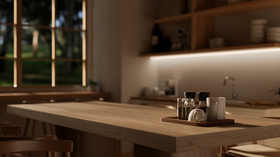 Close-up image of a hardwood dining table in a modern, Scandinavian kitchen with dim light from a light under the wall cabinet. 3d render, 3d illustration