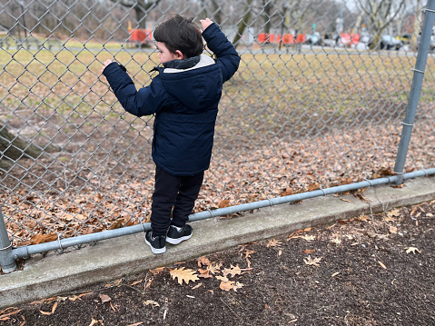 View of a boy climbs fence