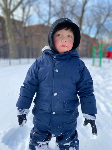 Front view of a boy playing with snow