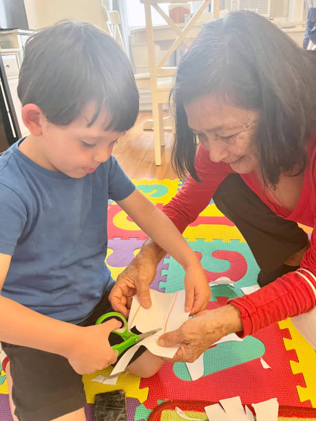 istock Boy cutting paper with his grandmother 1974109093