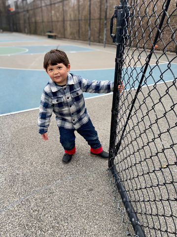View of a boy closing gate at playground