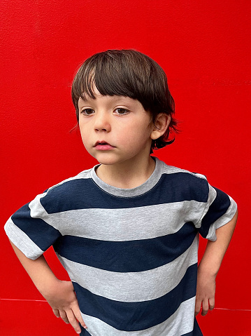Portrait of a little boy on red background
