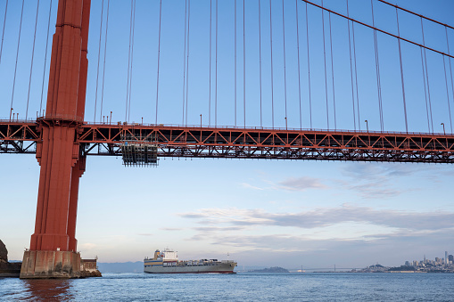 View of Golden Gate Bridge over bay and freighter at sunset