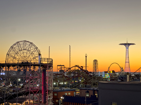 New York City, NY, USA - November 18 2023: Sunset view in Coney Island, Brooklyn during sunset with amusement park  in the foreground