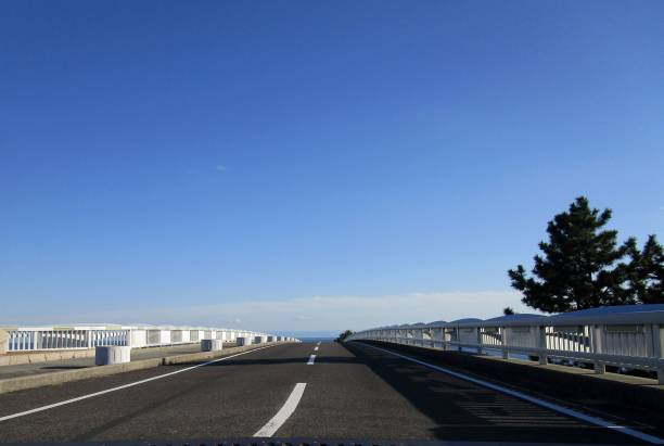 A single road stretches as if it continues into the sky.