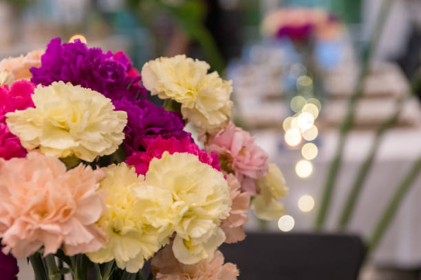 istock Flower settings on the table for fine dining at restaurant with bokeh light on background. 1974289409