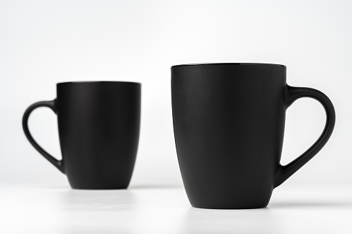 Black coffee mugs mock up on white background copy space close up