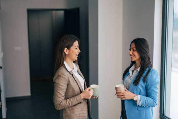 istock Two young colleagues chatting in office hallway 1974322769