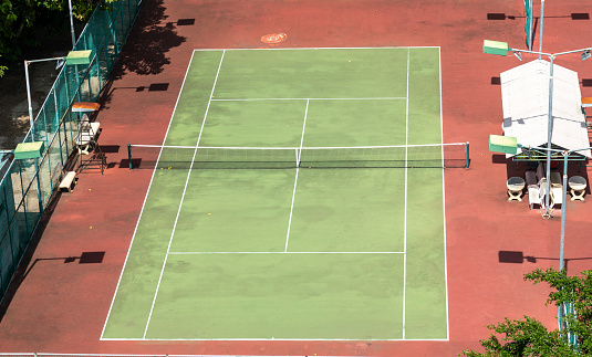 top view tennis court. court, bathed in sunlight, provides an inviting space for recreational tennis matches amidst nature's tranquility.