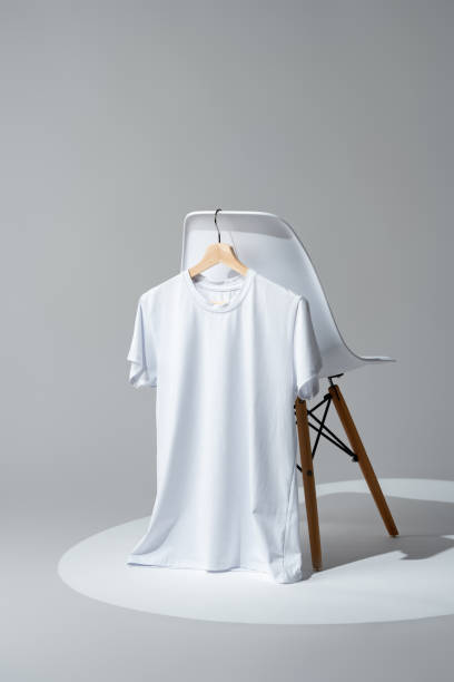 istock White blank t-shirt hanging on chair in empty room 1974331012
