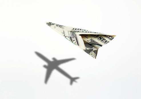 One hundred dollar paper airplane with a natural airplane shadow.Concept for travel, business idea, leadership, success, teamwork, creative idea, vision