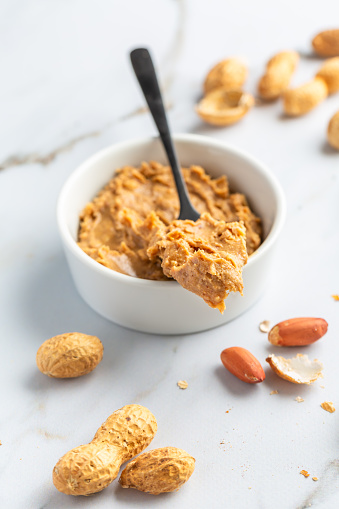 Bowl with homemade crunchy peanut butter and heap of nuts