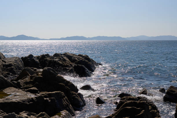 Glittering sea surface and rocky landscape.
