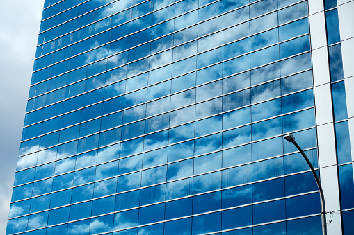 The blue sky reflected in the window glass of the building.