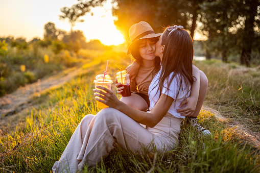 Photo of a girl and her mother spending time together in the field on a great sunny day.