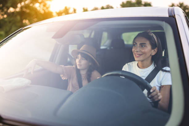 istock Mother and daughter travelling by a car 1974373109